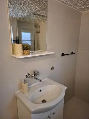 a bathroom with a sink and a mirror at Fly & Stay Apartments in Laktaši