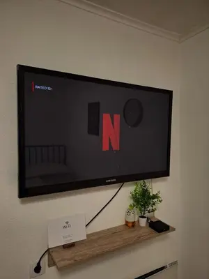 a flat screen tv hanging on a wall at Fly & Stay Apartments in Laktaši