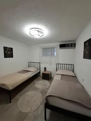 two beds in a room with two rugs at Fly & Stay Apartments in Laktaši