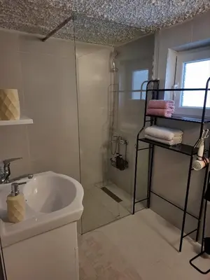 a bathroom with a glass shower and a sink at Fly & Stay Apartments in Laktaši