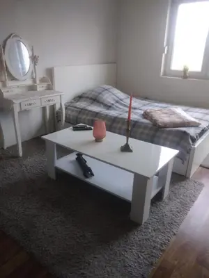 a room with a bed and a table with a candle on it at Etno domaćinstvo in Bosanska Dubica