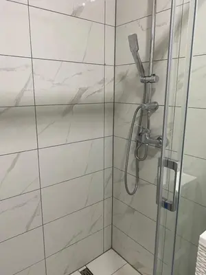 a bathroom with a shower with white tiles at Vista Castle in Jajce
