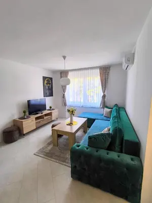 a living room with a green couch and a table at Esma in Bihać