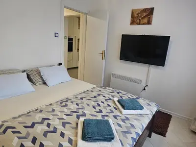 a bedroom with a bed with a flat screen tv on the wall at Esma in Bihać