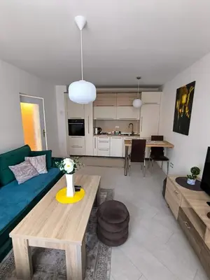 a living room with a blue couch and a table at Esma in Bihać