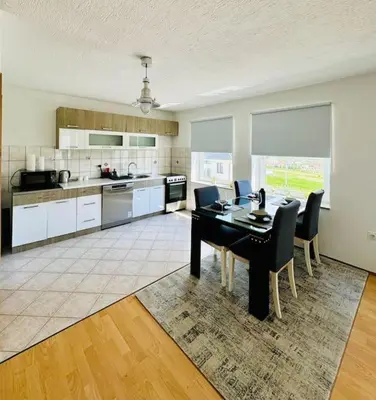 a kitchen with a black table and chairs in a room at Apartman Latice in Tomislavgrad