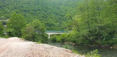 a bridge over a river with a train on it at Riverstone Retreat in Jajce