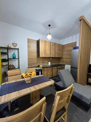 a kitchen with a table and chairs and a refrigerator at Riverstone Retreat in Jajce