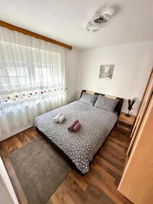 a bedroom with a bed with two pillows and a window at Apartman Lara Laktasi in Laktaši