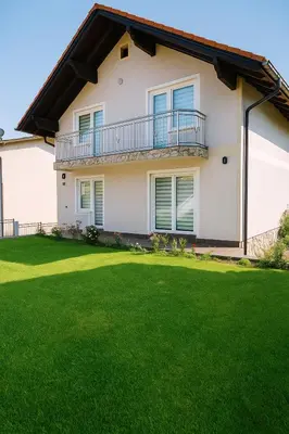 a house with a green lawn in front of it at Guesthouse Nestoria Living in Banja Luka