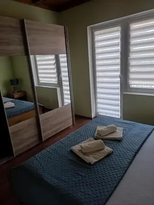 a bedroom with two towels on a bed with a mirror at Guesthouse Nestoria Living in Banja Luka