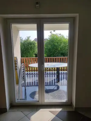 a sliding glass door with a table and a table at Guesthouse Nestoria Living in Banja Luka