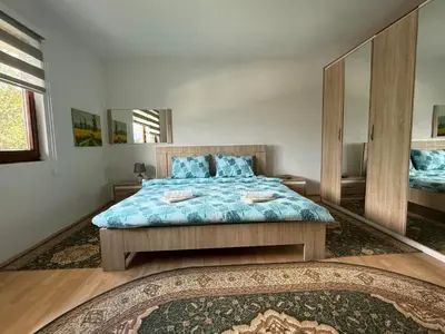 a bedroom with a large bed and a mirror at Comfort house near pyramides in Visoko