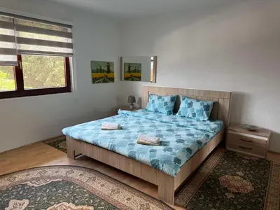 a bedroom with a large bed with blue sheets and pillows at Comfort house near pyramides in Visoko