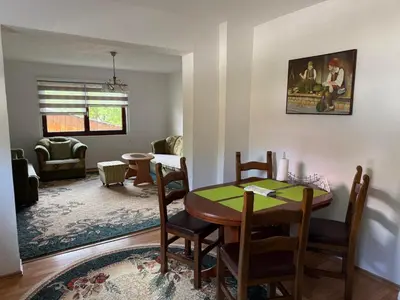 a dining room and living room with a table and chairs at Comfort house near pyramides in Visoko