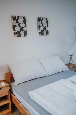 a bed in a room with two pictures on the wall at MASAL Studio Apartman in Bihać