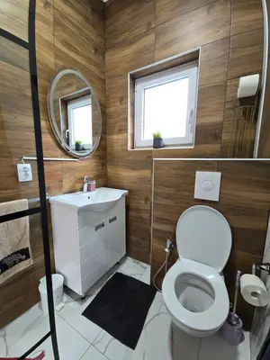 a bathroom with a toilet and a sink and a mirror at Riverstone Retreat Villa in Jajce