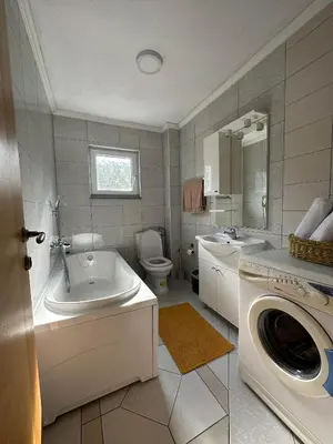 a bathroom with a sink and a washing machine at Riverstone Retreat Villa in Jajce