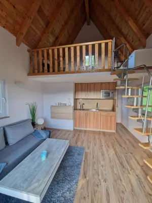 a living room with a blue couch and a staircase at Weekend House Sunset in Zapoljak