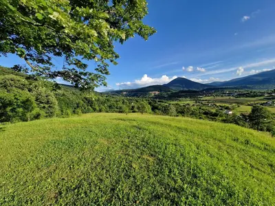 a green field with mountains in the background at Weekend House Sunset in Zapoljak