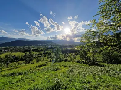 a view of a green field with the sun in the sky at Weekend House Sunset in Zapoljak