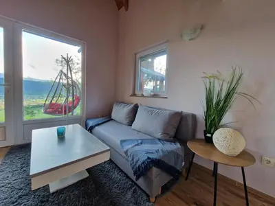 a living room with a couch and a table at Weekend House Sunset in Zapoljak