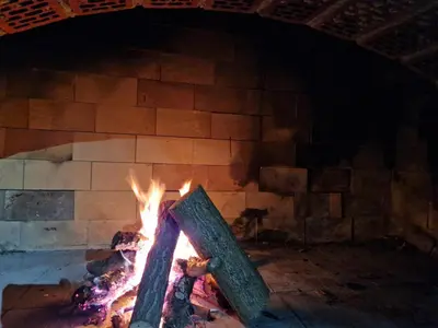a brick oven with a fire in it at Weekend House Sunset in Zapoljak