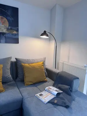 a blue couch with yellow pillows and a book on it at City centar Travnik-free parking in Travnik