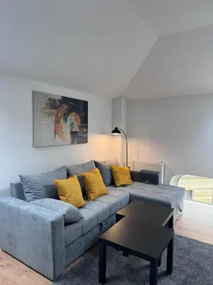 a living room with a blue couch with yellow pillows at City centar Travnik-free parking in Travnik