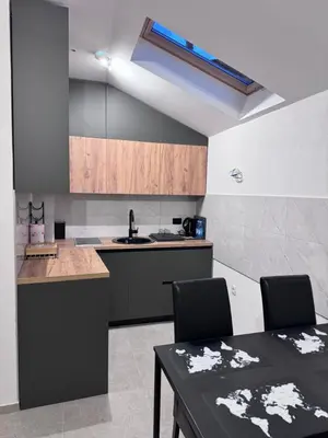 a kitchen with a table and two chairs and a sink at City centar Travnik-free parking in Travnik