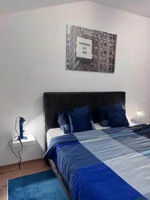 a bedroom with a bed with blue and white sheets at City centar Travnik-free parking in Travnik