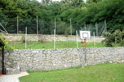 a stone wall with a basketball hoop on top of it at Djuric Vacation House in Laktaši