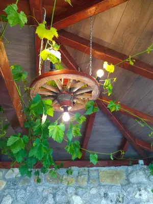 a wooden ceiling with a chandelier with flowers on it at Djuric Vacation House in Laktaši