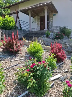 a garden with flowers in front of a house at Djuric Vacation House in Laktaši