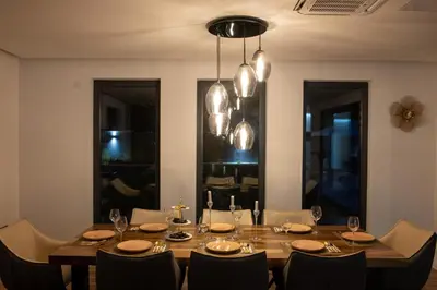 a dining room with a table with chairs and aendant light at Villa of Senses in Bihać