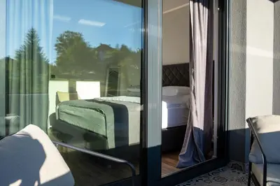 a room with a balcony with a bed and a window at Villa of Senses in Bihać