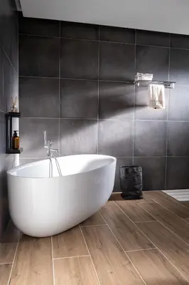 a white bath tub in a bathroom with black tiles at Villa of Senses in Bihać