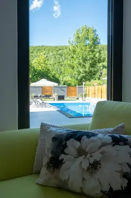 a pillow sitting on a couch in front of a window at Villa of Senses in Bihać