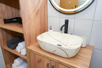 a bathroom with a marble sink on a wooden shelf at Palma in Jajce