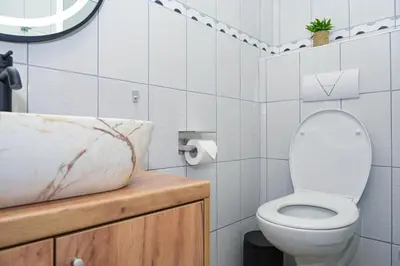 a bathroom with a white toilet and a sink at Palma in Jajce