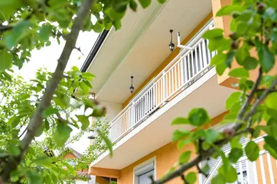 a balcony of a building with trees in the foreground at Palma in Jajce