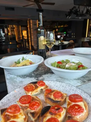 a table with plates of food and a glass of wine at CASA V BENCUN Deluxe Queen Rooms in Kiseljak