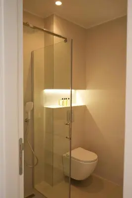 a bathroom with a toilet and a glass shower stall at CASA V BENCUN Deluxe Queen Rooms in Kiseljak