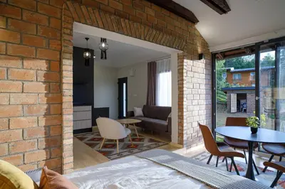 a brick room with a bed and a table and chairs at BLOK- Brick and wood cottage in Visoko