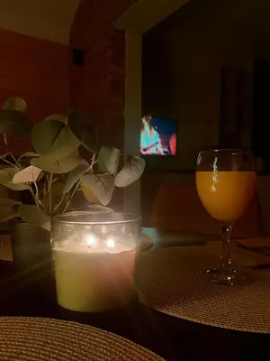 a table with a candle and a glass of wine at BLOK- Brick and wood cottage in Visoko