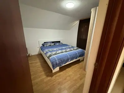 a bedroom with a bed with a blue comforter at Stan na dan Banjaluka in Banja Luka