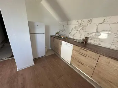 a kitchen with a white refrigerator and wooden cabinets at Stan na dan Banjaluka in Banja Luka