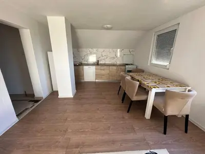 a kitchen and dining room with a table and chairs at Stan na dan Banjaluka in Banja Luka