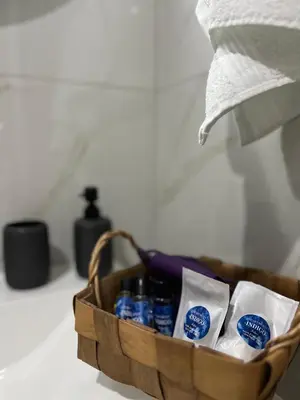 a wooden basket with bottles of toothpaste and towels at Apartments Indigo in Jajce