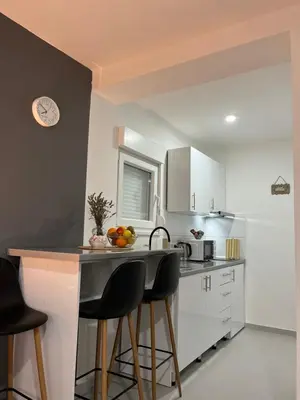 a kitchen with a counter with stools and a sink at Apartments Indigo in Jajce